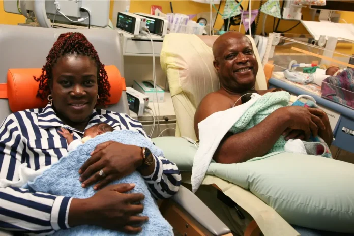 Mutter und Vater halten Frühgeborene im Arm auf einer Neonatologie-Station