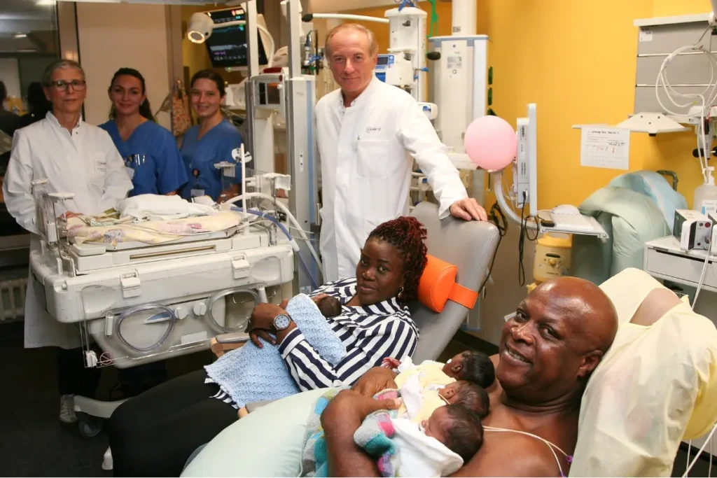 Eltern halten Frühgeborene im Spital, umgeben von medizinischem Personal