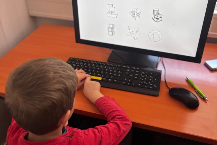 Bub macht Aufmerksamkeitstest am Computer mit Symbolbildern – Life Child-Studie Leipzig.