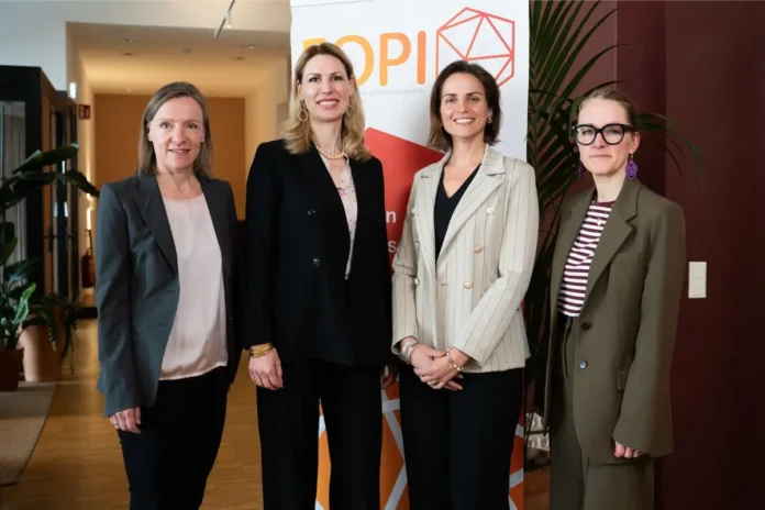 Vier Frauen stehen nebeneinander vor einem FOPI-Banner in einem Innenraum und schauen in die Kamera.