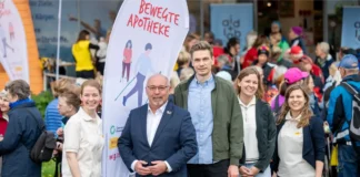 Teilnehmende beim Auftakt der Bewegten Apotheke in Hernals mit Nordic Walking vor einer Apotheke
