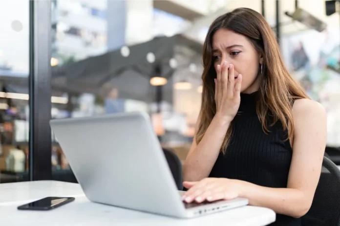 Frau schaut besorgt auf Laptop und googelt Symptome – Cyberchondrie und Gesundheitsangst durch Internetrecherche