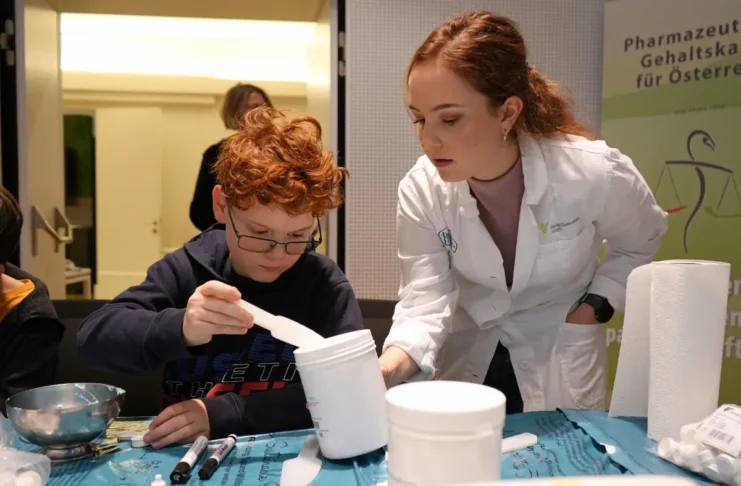 Kind rührt Salbe bei der Kinderapotheke im Apothekerhaus Wien unter Anleitung einer Pharmazeutin