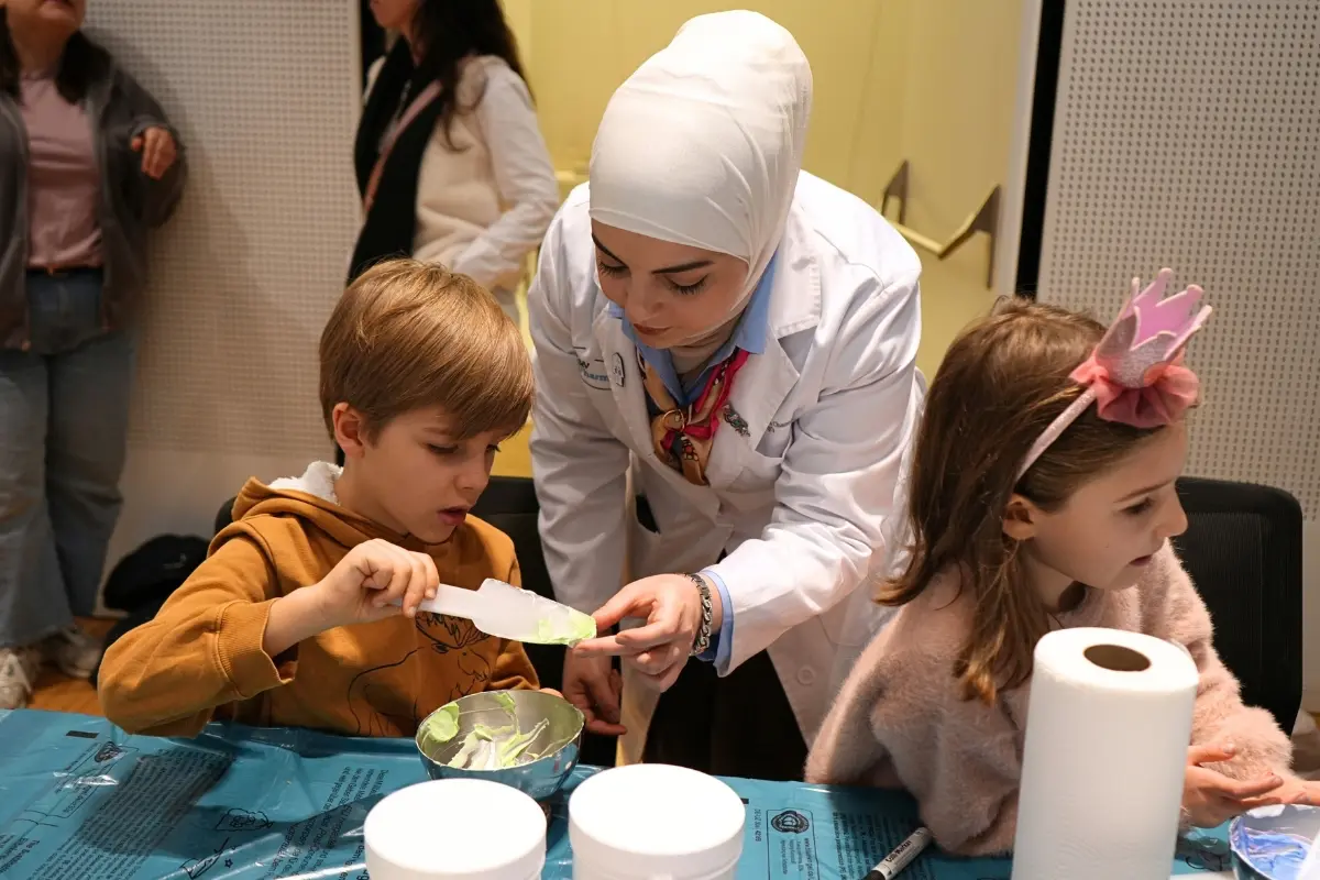 Kind rührt bei der Kinderapotheke im Apothekerhaus Wien unter Anleitung eine Salbe