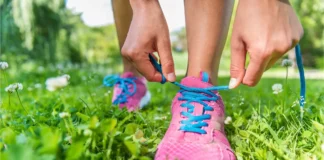 Person bindet Laufschuhe im Gras während der Pollensaison