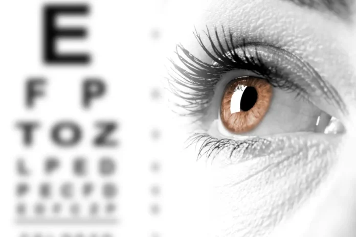 Nahaufnahme eines Auges vor einem Sehtest mit Buchstaben
