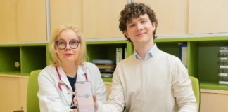 Ärztin und junger Mann zeigen den digitalen Survivorship Passport auf einem Smartphone im St. Anna Kinderspital