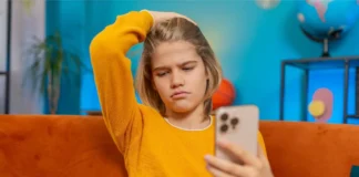 Jugendliche Person blickt kritisch auf Smartphone mit TikTok-Inhalten zur psychischen Gesundheit