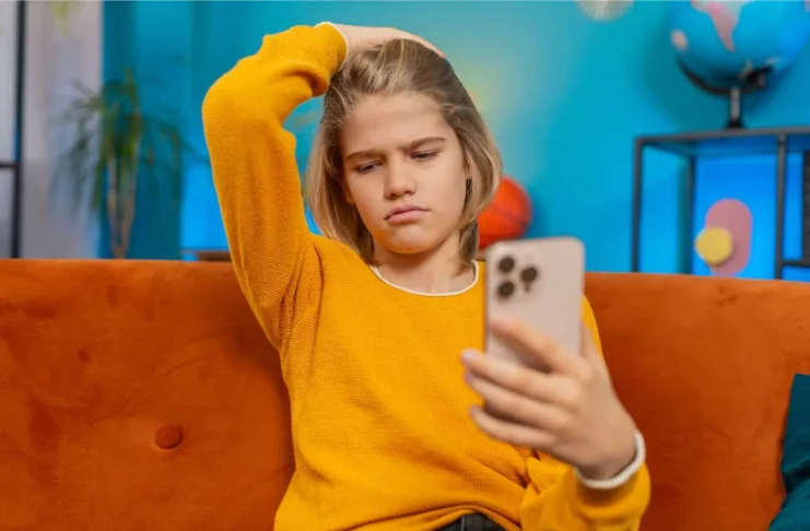 Jugendliche Person blickt kritisch auf Smartphone mit TikTok-Inhalten zur psychischen Gesundheit