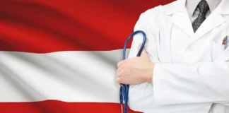Arzt mit Stethoskop vor österreichischer Flagge als Symbol für das Gesundheitssystem in Österreich