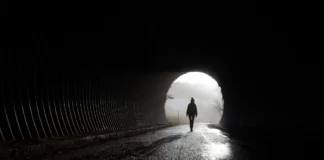 Silhouette einer Person am Ausgang eines Tunnels als Symbolbild für psychische Erkrankungen und mentale Gesundheit