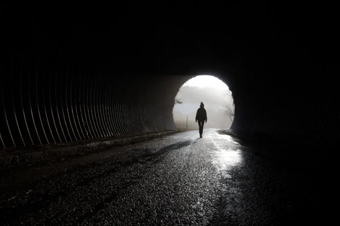 Silhouette einer Person am Ausgang eines Tunnels als Symbolbild für psychische Erkrankungen und mentale Gesundheit