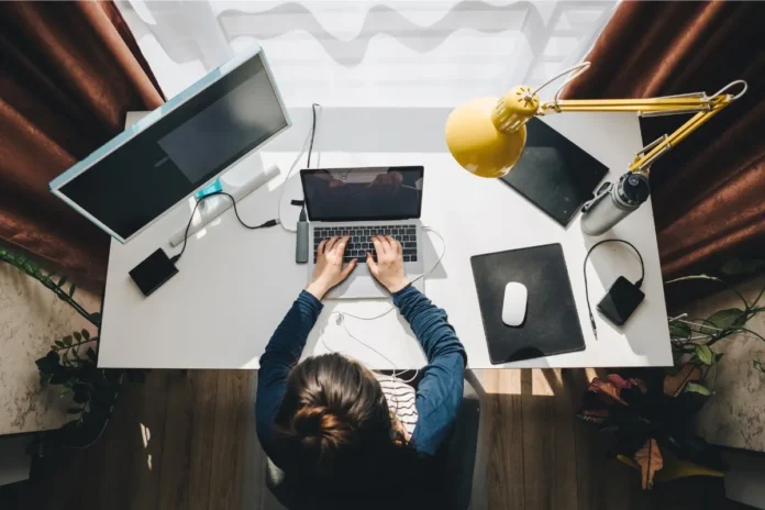 Person arbeitet im Homeoffice an einem Laptop; Studie untersucht mögliche Auswirkungen auf die psychische Gesundheit.