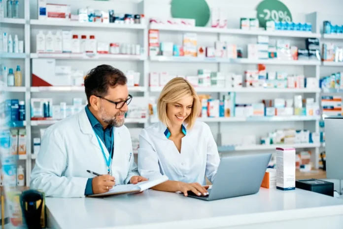 Apothekerin und Apotheker arbeiten gemeinsam in einer öffentlichen Apotheke.