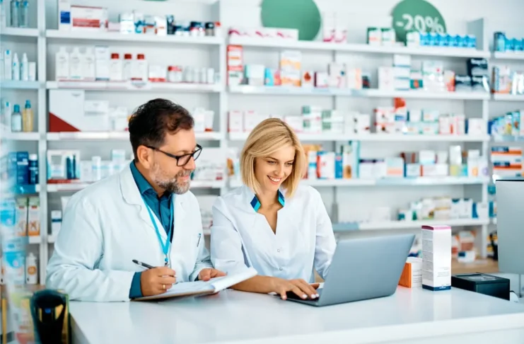 Apothekerin und Apotheker arbeiten gemeinsam in einer öffentlichen Apotheke.