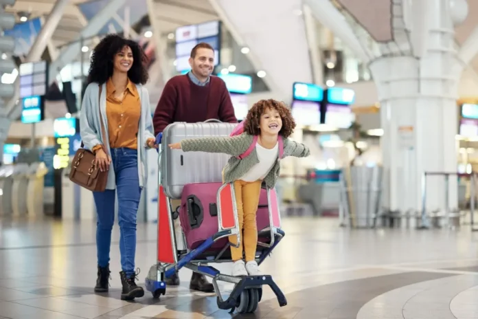Familie mit Reisegepäck am Flughafen – e-card und Europäische Krankenversicherungskarte bieten Versicherungsschutz im Ausland.