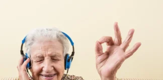Ältere Frau hört mit Kopfhörern Musik und lächelt entspannt.