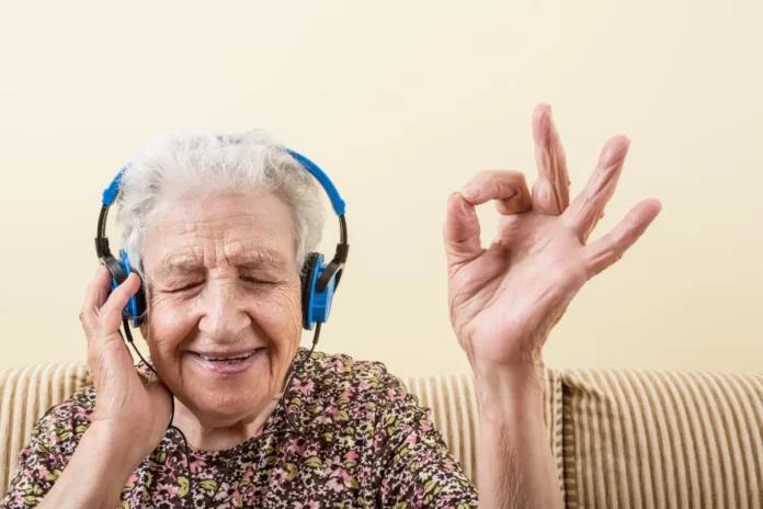 Ältere Frau hört mit Kopfhörern Musik und lächelt entspannt.