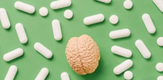 Modell eines Gehirns umgeben von Tabletten als Symbolbild für den Placeboeffekt und die Schmerzlinderung.
