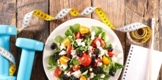 Salat mit Hanteln und Maßband als Symbol für Prävention durch Ernährung und Bewegung.