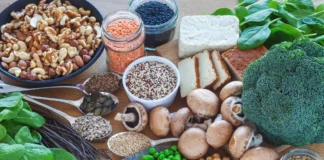 Pflanzliche und tierische Proteinquellen wie Hülsenfrüchte, Nüsse, Tofu, Brokkoli und Pilze auf einem Tisch.