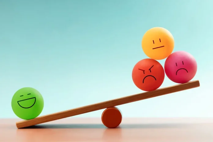Waage mit farbigen Kugeln als Symbol für den Zusammenhang zwischen Stressanfälligkeit und emotionalem Gleichgewicht.