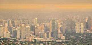 Luftverschmutzung über einer Großstadt mit dichter Bebauung und Smog als Symbol für ultrafeine Partikel.