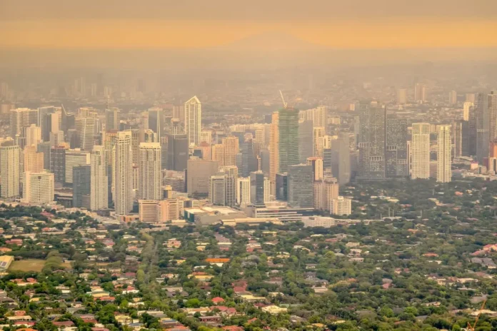 Luftverschmutzung über einer Großstadt mit dichter Bebauung und Smog als Symbol für ultrafeine Partikel.