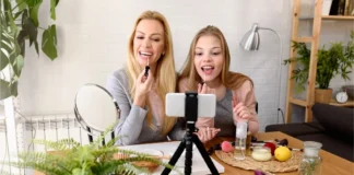 Kosmetik bei Kindern und Jugendlichen: Junge Frau und Mädchen verwenden Kosmetik vor einer Smartphone-Kamera.