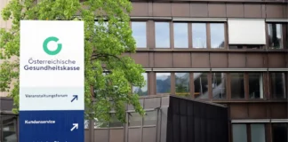Schild der Österreichischen Gesundheitskasse vor einem ÖGK-Gebäude