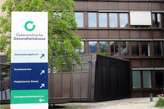 Schild der Österreichischen Gesundheitskasse vor einem ÖGK-Gebäude
