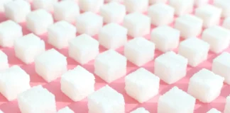 Weiße Zuckerwürfel auf rosafarbenem Hintergrund