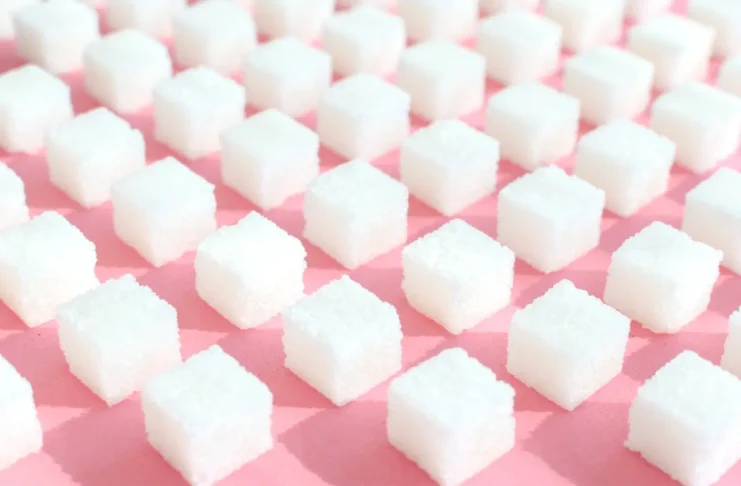 Weiße Zuckerwürfel auf rosafarbenem Hintergrund