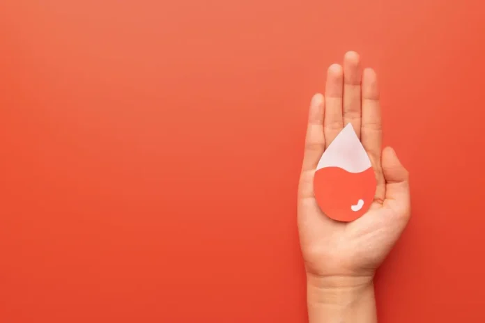 Hand mit stilisiertem Bluttropfen als Symbol für Eisenmangel und Ferritin