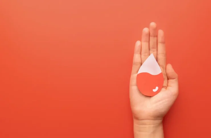 Hand mit stilisiertem Bluttropfen als Symbol für Eisenmangel und Ferritin