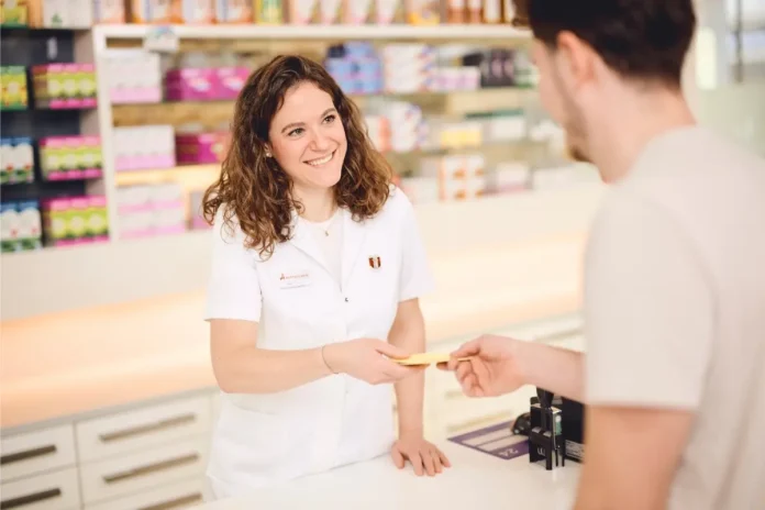 Mitarbeiterin einer Apotheke im Gespräch mit einem Kunden an der Tara